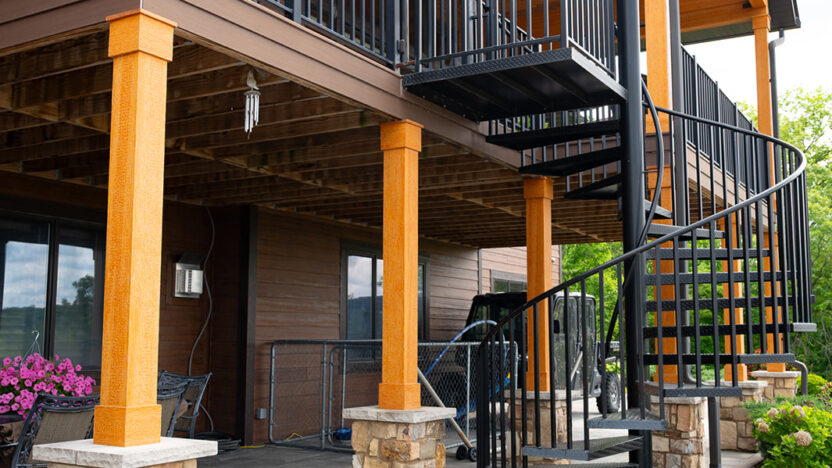 Large modern back patio of a custom home featuring a black metal staircase