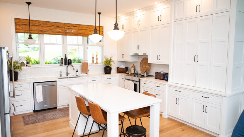 Kitchen Renovations project example by Custom Pro Homes. A bright, modern kitchen featuring white cabinets, hard-wood floors, and sleek, modern black fixtures.