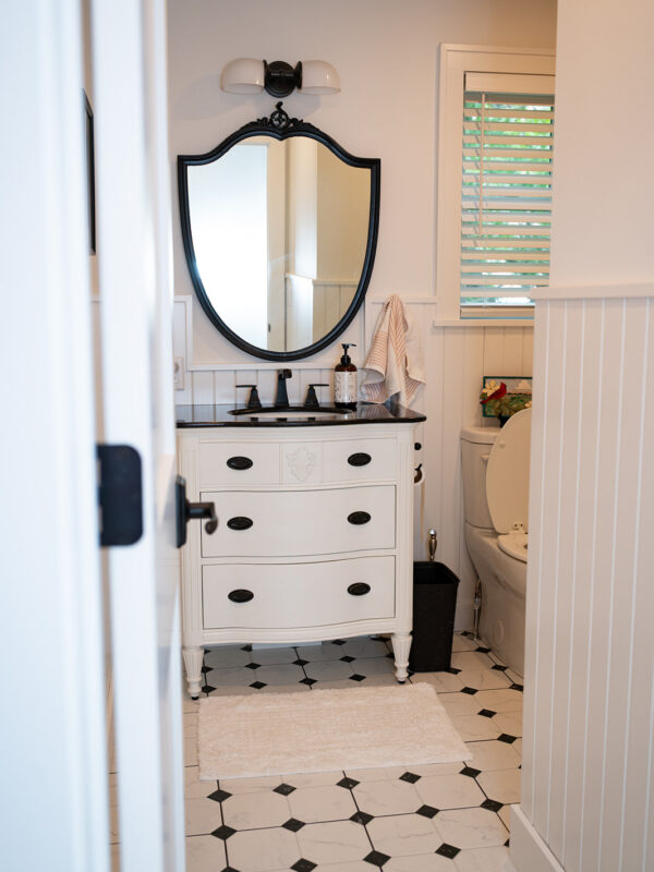 Interior photo of a newly built bathroom with vintage tiles and a unique shield mirror
