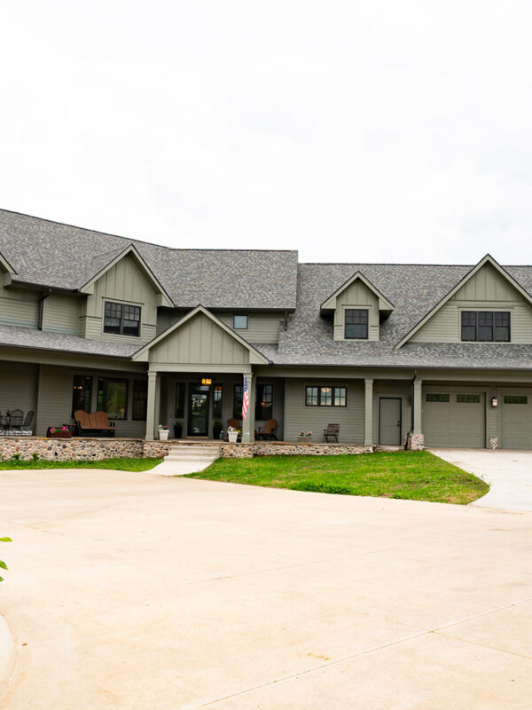 Front side of a custom green luxury lake house in North Liberty, Iowa