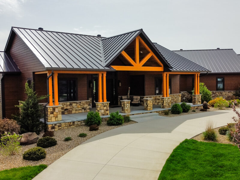 Driveway view of a custom luxury home built in North Liberty Iowa, featuring red oak and black metal